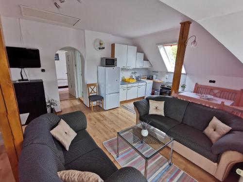 a living room with a couch and a kitchen at Landhaus Forrás in Balatonfüred