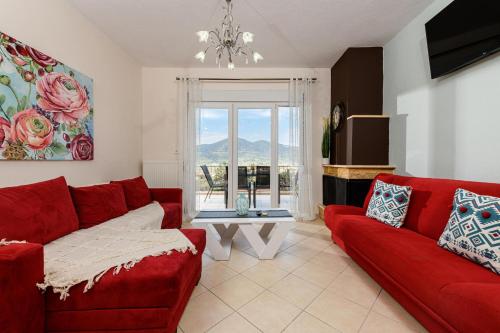 ein Wohnzimmer mit einem roten Sofa und einem Tisch in der Unterkunft Villa Panorama in Skala Potamias