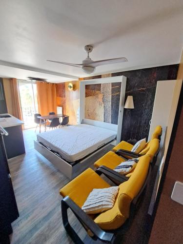 1 Schlafzimmer mit einem großen Bett und 2 Stühlen in der Unterkunft Appartement avec parking Cap d'Agde, La Falaise in Cap d'Agde
