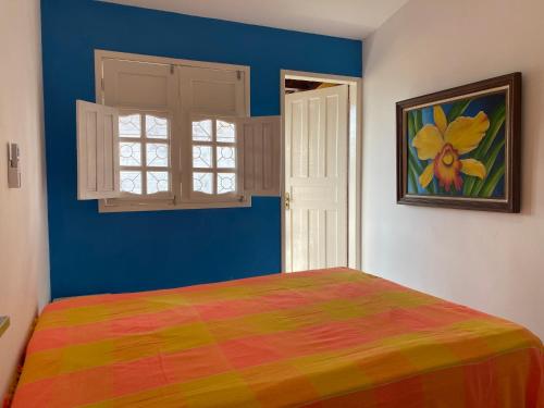 a bedroom with a colorful bed and a window at Tamandaré 100m das piscinas naturais 600m da Divisa dos Carneiros in Tamandaré