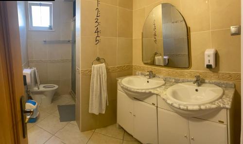a bathroom with two sinks and a mirror and a toilet at Lagos Marina Guest House in Lagos