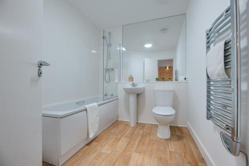 a white bathroom with a toilet and a sink at Charltons Bonds Apartments 22 by Week2Week in Newcastle upon Tyne