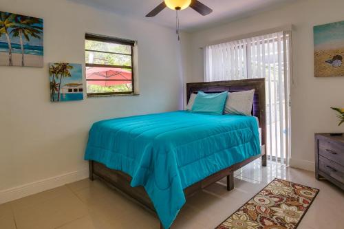 a bedroom with a bed with a blue comforter at Margate Home with Hot Tub and Putting Green! in Margate