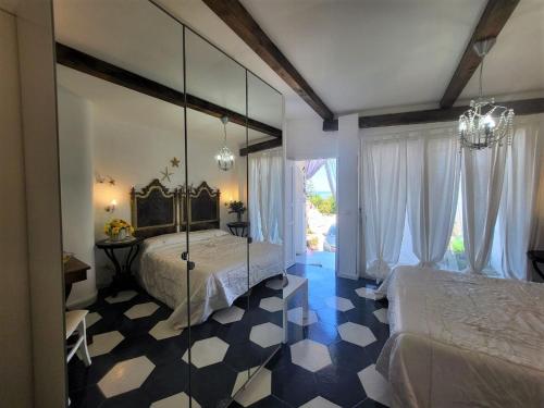 1 Schlafzimmer mit 2 Betten und einem Spiegel in der Unterkunft Casa Vacanze Miceli in Tropea