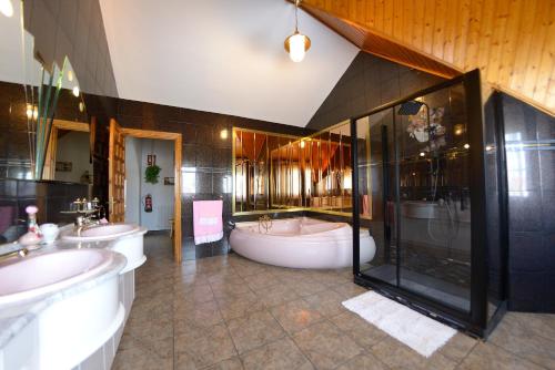a large bathroom with two sinks and a tub at Villa Meli in Villarejo de Salvanés