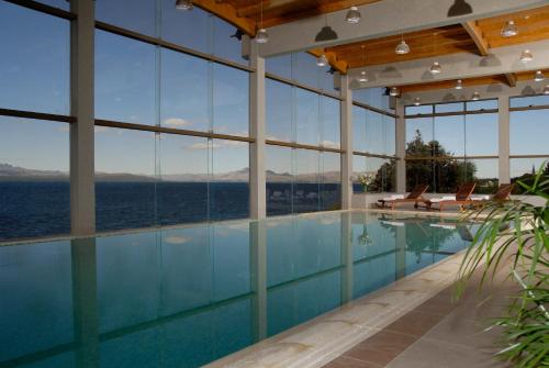 uma piscina com vista para a água em Alma Del Lago Suites & Spa em San Carlos de Bariloche