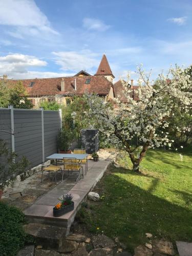 um pátio com uma mesa e cadeiras num jardim em Les Ouches em Saint-Blaise