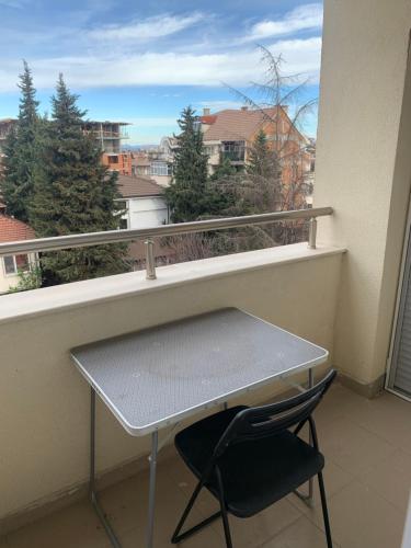 einen Tisch und einen Stuhl auf einem Balkon mit einem Fenster in der Unterkunft Pazardzhik suite home in Pasardschik