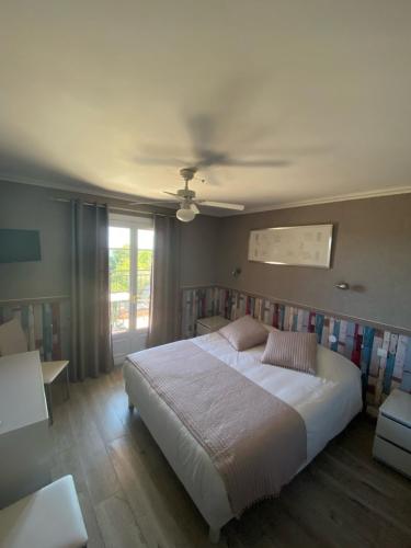 a bedroom with a large white bed and a window at Les Belles Terrasses in Tourrettes-sur-Loup