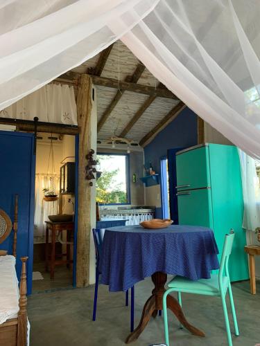 a kitchen with a blue table and a white ceiling at Chalé Perto Do Céu in São Thomé das Letras