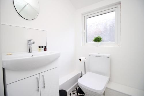 biała łazienka z umywalką i toaletą w obiekcie No 9 Afan Valley House by SSW FREE Parking w mieście Glyncorrwg