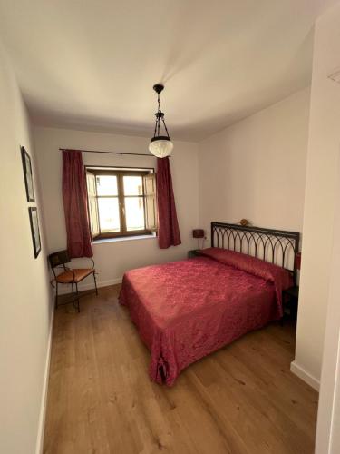 a bedroom with a red bed and a window at Loreto N1 in Denia