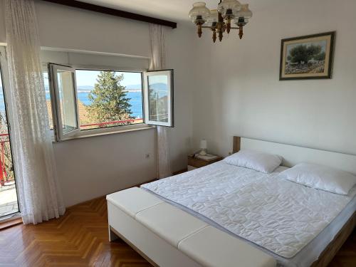 - une chambre blanche avec un lit et 2 fenêtres dans l'établissement Spacious 2-room apartment with beautiful sea view, à Crikvenica