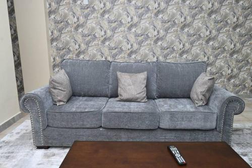 a gray couch with pillows in a living room at Greybun House 1 Bedroom in Nanyuki