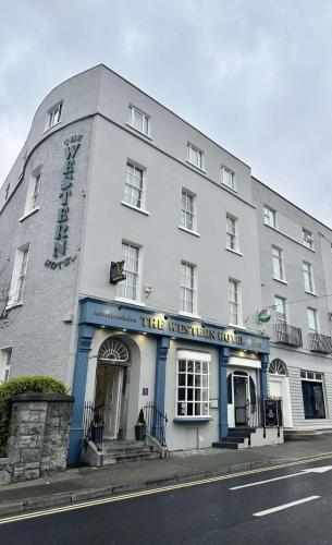 a white building on the corner of a street at The Western Hotel in Galway