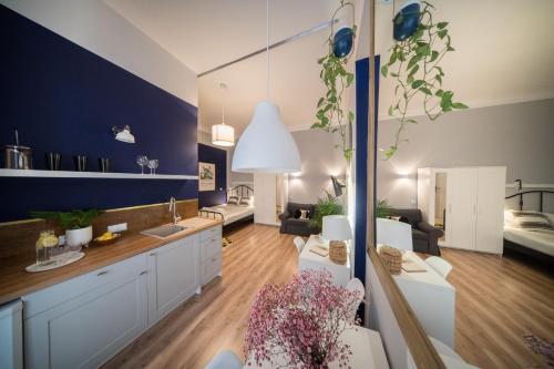 cocina y sala de estar con pared azul en Roller Aparthotel, en Cracovia