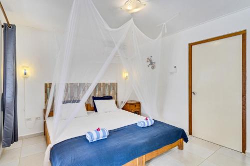 a bedroom with a bed with a blue blanket at Tropical Divers Resort in Kralendijk