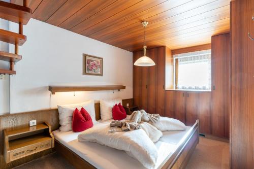 a bedroom with a large bed with red pillows at Haus Anemone in Seefeld in Tirol