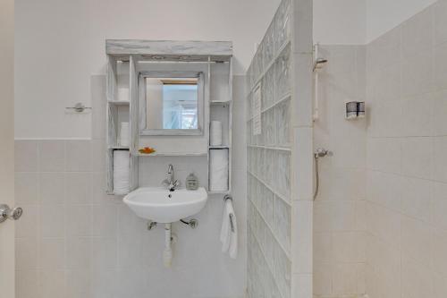 a white bathroom with a sink and a mirror at Tropical Divers Resort in Kralendijk