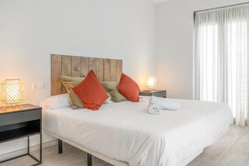 1 dormitorio con 1 cama blanca grande con almohadas de color naranja en GAV Cerrillo en Ronda