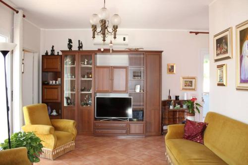 ein Wohnzimmer mit einem großen Entertainment-Center mit einem TV in der Unterkunft Vida Noa - Casa vista mare - Sud Sardegna in Nebida