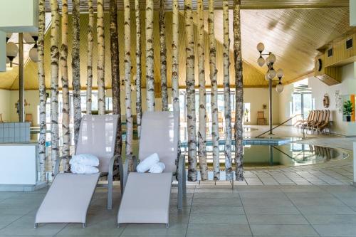 un grupo de sillas blancas en una habitación en Terme Banovci - Hotelsko naselje Zeleni gaj, en Banovci