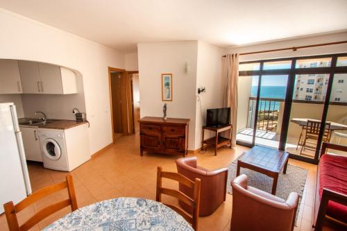 a kitchen and living room with a view of the ocean at Colmeia- Alojamento Local in Armação de Pêra