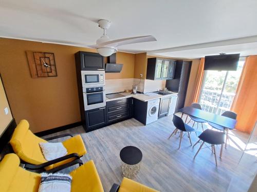 salon z żółtą kanapą i kuchnią w obiekcie Appartement avec parking Cap d'Agde, La Falaise w Cap d'Agde