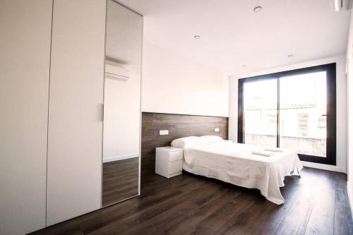 1 dormitorio con cama y ventana grande en 4-1 Apartamento de diseño en el centro de Reus, en Reus