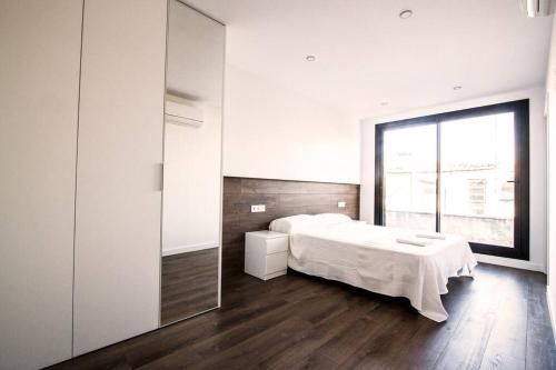 1 dormitorio con cama y ventana grande en 4-1 Apartamento de diseño en el centro de Reus en Reus