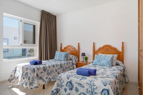 a bedroom with two beds and a window at Callao Beach 9 in Arrieta