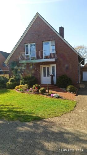 a brick house with a porch and a yard at Ferienhaus am Dreieck in Renkenberge