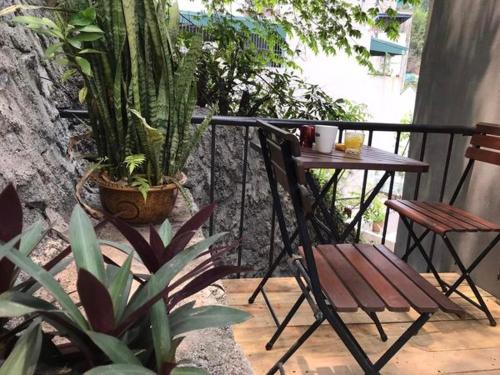 a table and a chair on a balcony with plants at Homestay giường tầng view thoáng tại Bãi Cháy Hạ Long in Ha Long