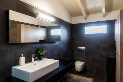 a bathroom with a white sink and a toilet at Inalia Modern House in Lefkimmi