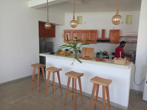 a man in a kitchen with a counter with stools at Lihinya Beach Villa Ahangama in Ahangama