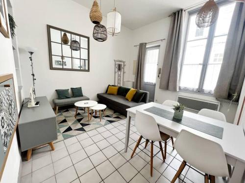un salon avec un canapé, une table et des chaises dans l'établissement Cour Passy - Centre ville, à La Rochelle
