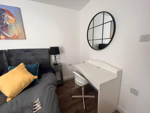 a bedroom with a bed and a desk and a mirror at Star London Vivian Avenue 1-Bed Hideaway with Garden in Hendon