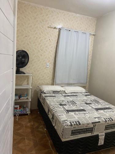 a small bedroom with a bed with a curtain at Casinha Valdenia: No paraíso com Wi-Fi, em Mundaú in Trairi