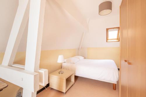 een kleine slaapkamer met een wit bed en een raam bij Calme et lumière à proximité de la Vieille Ville de Boulogne sur mer in Boulogne-sur-Mer