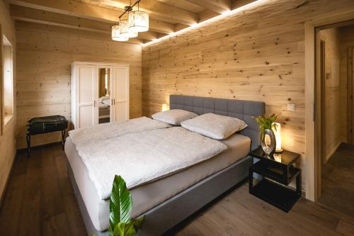 ein Schlafzimmer mit einem Bett in einer Holzwand in der Unterkunft Chalet 49 Nesselgraben - Ferienwohnungen aus Holz in Koppl