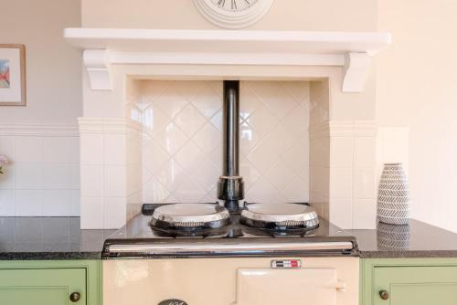 a kitchen with a stove with two pans at Hillcrest, Aldeburgh in Aldeburgh