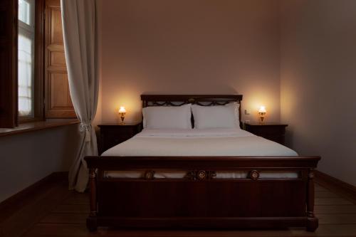 a bedroom with a bed with two lights on it at Antoinette Mansion in Hydra