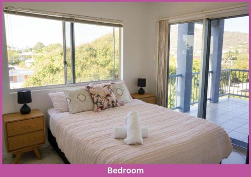 a bedroom with a large bed with a large window at The Strand Mirage in Townsville