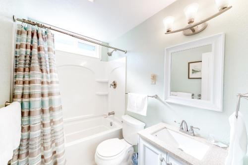 a bathroom with a sink and a toilet and a mirror at Captain's Choice 360 in Frisco