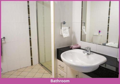 a bathroom with a white sink and a shower at The Strand Mirage in Townsville