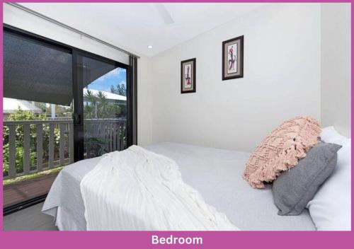 a bedroom with a bed and a large window at Little Villa in Aitkenvale