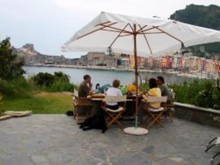 Un groupe de personnes assises à une table sous un parapluie dans l'établissement La Casa Del Pescatore B&B, à Portovenere