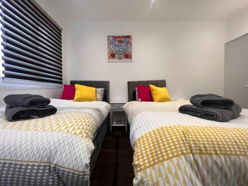 two beds sitting next to each other in a room at Star London Finchley Road 2-Bed Residence in London