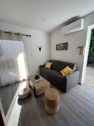 a living room with a couch and a coffee table at "Le nature" Camargue Jardin in Arles