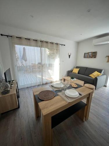 a living room with a table and a couch at "Le nature" Camargue Jardin in Arles